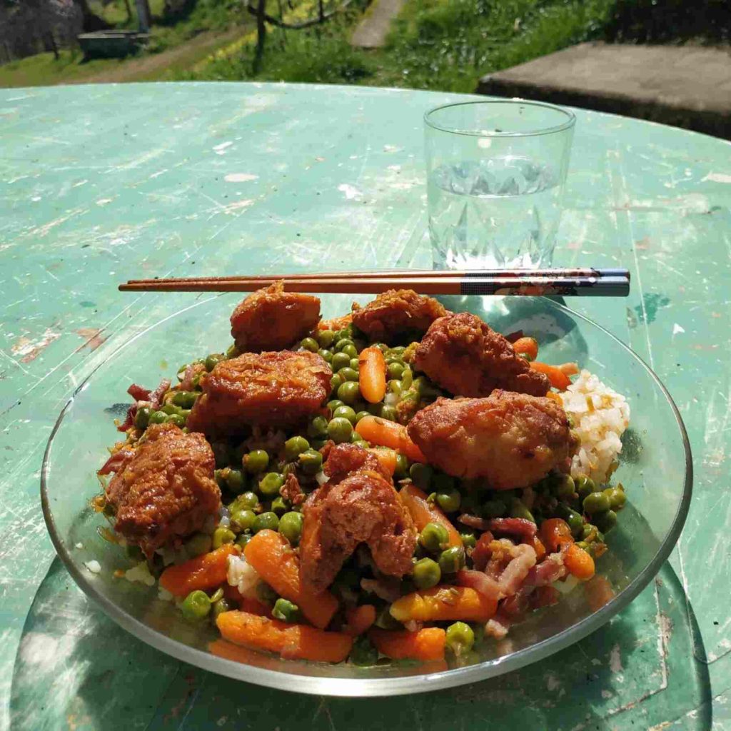 Déjeuner avec du poulet frit japonais karaage du riz et un mélange petits pois et carottes