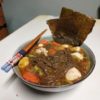 Un bol a repas japonais avec des nouilles soba du bouillon des légumes et du poulet