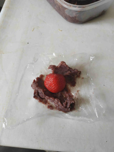 une fraise avec en dessous de la pâte de haricots rouges sucrée qu'on appelle anko au Japon