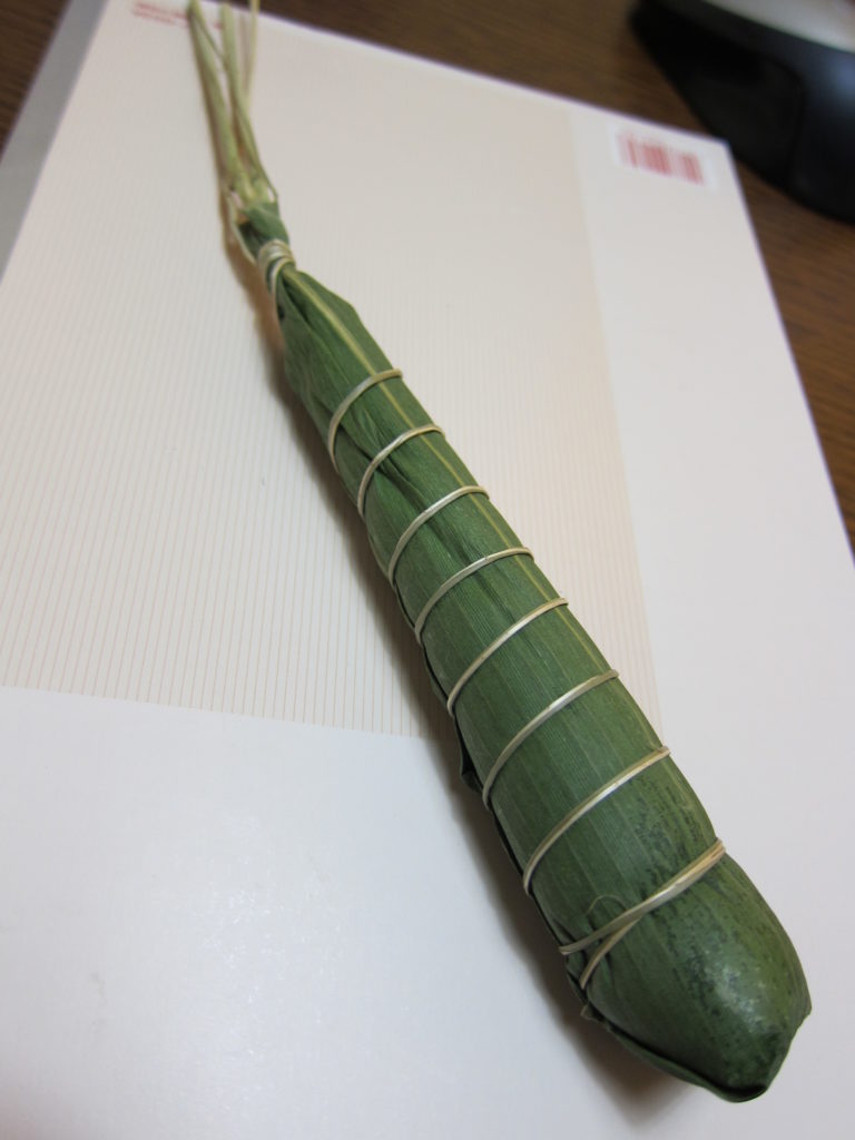 boulette de riz fourrée, sucrée ou salée, enroulée dans une feuille de bambou