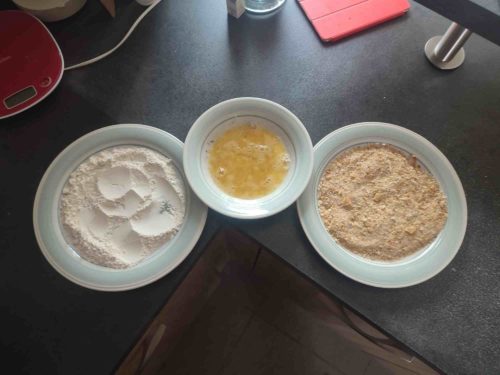 de gauche à droite on voit de la farine dans une assiette, puis des oeufs battus dans un bol, puis de la chapelure japonaise panko. Le tout servira pour faire des croquettes japonaises korokke