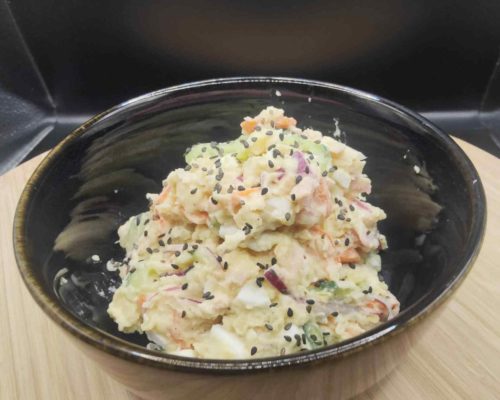 Une salade de pommes de terres japonaise, qu'on appelle potato sarada est servie dans un bol noir