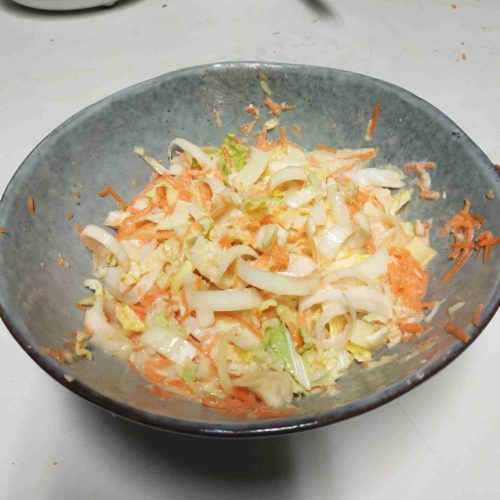 Les légumes sont mélangés dans un bol pour servir de base à l'okonomiyaki